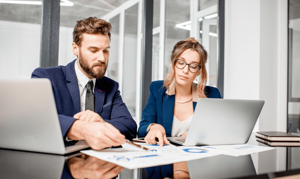IMAGEM1-ACADEMIARED.webp Imagem de um Homem e uma Mulher em reuniao e usando dois notebooks ( pagina Academia Educacional , pagina Sobre Academia Educacional )