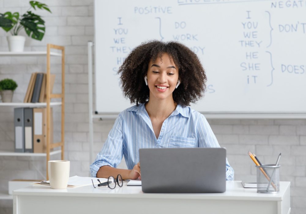 teacher-works-online-during-quarantine-woman-chatting-with-students-at-online-lesson-in-living-room.jpg Imagem jovem professora fazendo Mentoria para Gestores Educacionais em seu notebook
